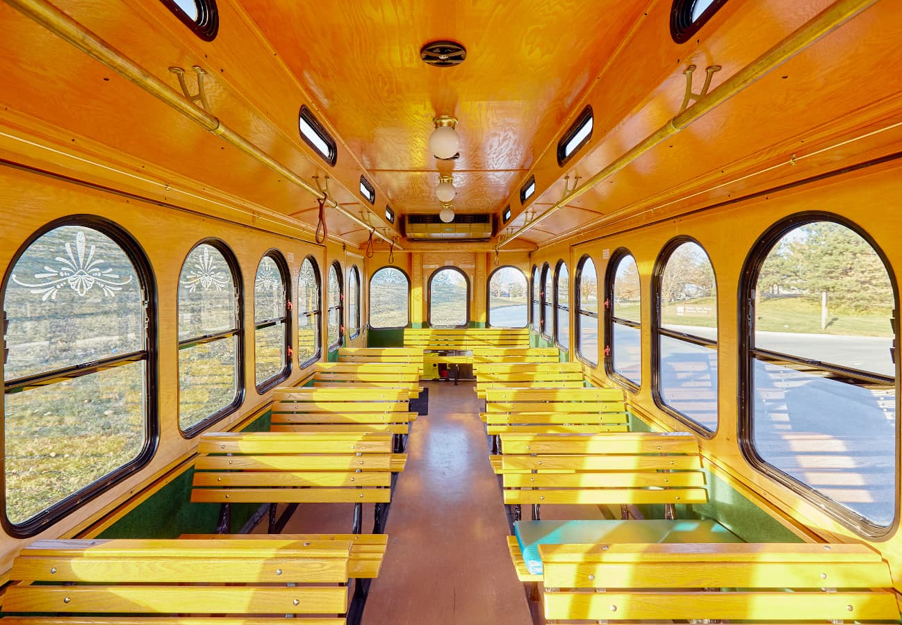 Vintage trolley interior with warm wooden benches and arched windows